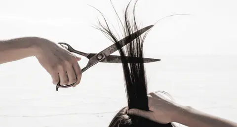 تفسير حلم قص الشعر يظهر في جو سينمائي صوفي، يرمز إلى التغيير والتعبير عن الذات.